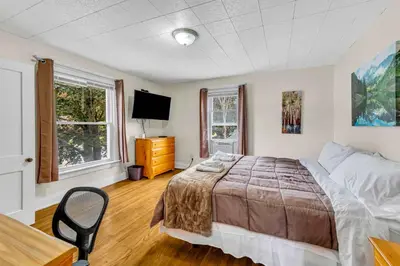 a bedroom with a bed and a desk and a tv at 2nd Base Apt 2 All Star Baseball Rentals in Oneonta
