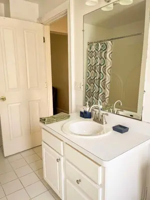 a bathroom with a white sink and a mirror at After the Game Apt 1 All Star Baseball Rentals in Oneonta