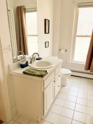 a white bathroom with a sink and a toilet at After the Game Apt 1 All Star Baseball Rentals in Oneonta