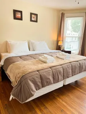 a bedroom with a large bed with two towels on it at After the Game Apt 1 All Star Baseball Rentals in Oneonta
