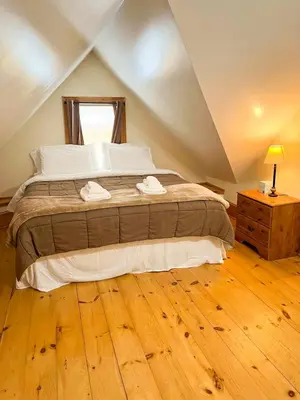 a bedroom with a large bed and a wooden floor at After the Game Apt 1 All Star Baseball Rentals in Oneonta