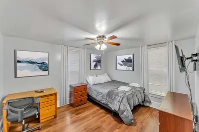 a bedroom with a bed and a desk and a ceiling fan at After the Game Apt 2 All Star Baseball Rentals in Oneonta