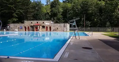 a large swimming pool with a building in the background at After the Game Apt 2 All Star Baseball Rentals in Oneonta