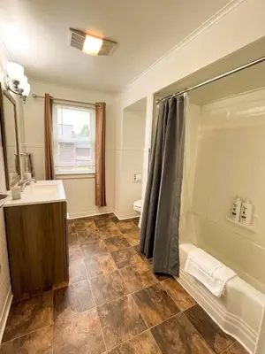 a bathroom with a shower curtain and a sink at Center Field All Star Baseball Rentals in Oneonta