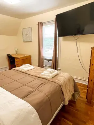 a bedroom with a bed with two towels on it at Center Field All Star Baseball Rentals in Oneonta