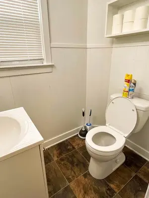 a bathroom with a toilet and a sink at Center Field All Star Baseball Rentals in Oneonta