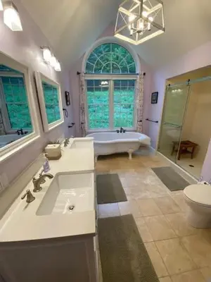 a bathroom with a tub and a sink and a toilet at Grand Slam Lake House Cooperstown Dreams Park in Cooperstown