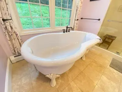 a white bath tub in a bathroom with a window at Grand Slam Lake House Cooperstown Dreams Park in Cooperstown