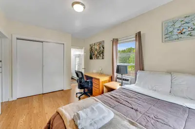a bedroom with a bed and a desk with a computer at Left Field All Star Baseball Rentals in Oneonta