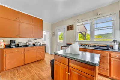 a large kitchen with wooden cabinets and a large window at Left Field All Star Baseball Rentals in Oneonta