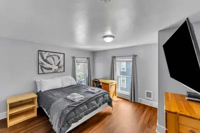 a bedroom with a bed and a flat screen tv at Right Field All Star Baseball Rentals in Oneonta