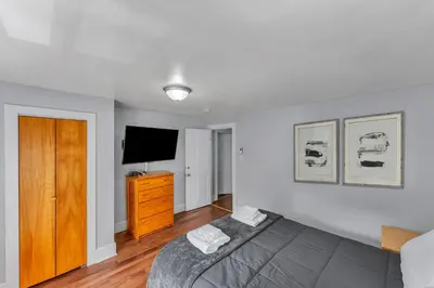 a bedroom with a bed and a flat screen tv at Right Field All Star Baseball Rentals in Oneonta