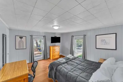 a bedroom with a bed and a desk and a television at Right Field All Star Baseball Rentals in Oneonta