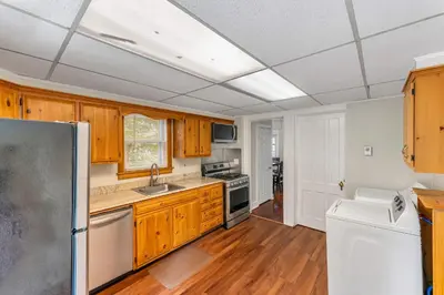 a kitchen with wooden cabinets and a refrigerator at Right Field All Star Baseball Rentals in Oneonta