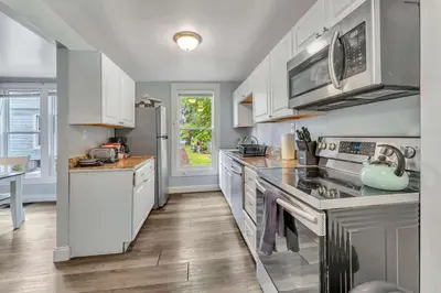 a kitchen with white cabinets and stainless steel appliances at Shortstop Apt 1 All Star Baseball Rentals in Oneonta