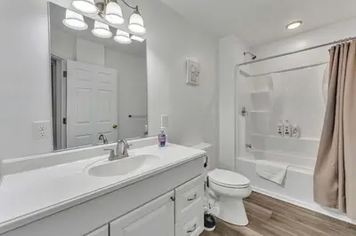 a white bathroom with a sink and a toilet at Shortstop Apt 1 All Star Baseball Rentals in Oneonta