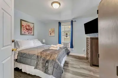 a bedroom with a bed and a flat screen tv at Shortstop Apt 1 All Star Baseball Rentals in Oneonta