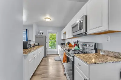 a kitchen with white cabinets and marble counter tops at Shortstop Apt 2 All Star Baseball Rentals in Oneonta