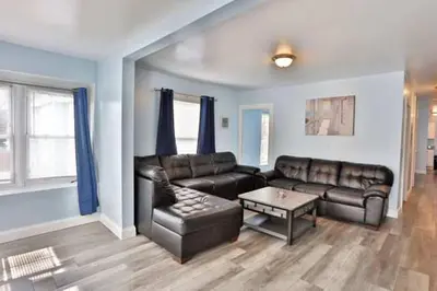 a living room with a leather couch and a table at Shortstop Apt 2 All Star Baseball Rentals in Oneonta