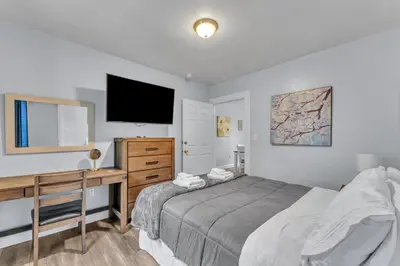 a bedroom with a bed and a desk and a television at Shortstop Apt 2 All Star Baseball Rentals in Oneonta