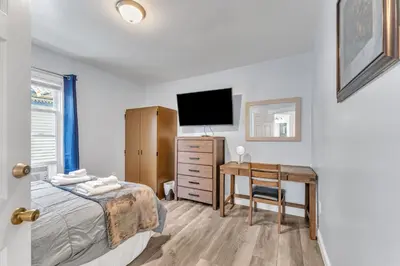 a bedroom with a bed and a desk with a television at Shortstop Apt 2 All Star Baseball Rentals in Oneonta