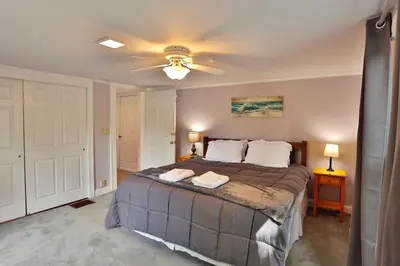 a bedroom with a bed with a ceiling fan at The Bullpen All Star Baseball Rentals in Oneonta