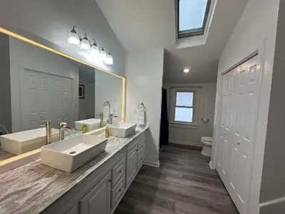 a bathroom with two sinks and a large mirror at The Bullpen All Star Baseball Rentals in Oneonta