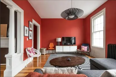 a living room with red walls and a wooden table at Hudson Valley Retreat in Downtown Hudson, NY - Sleeps 16-20 in Hudson