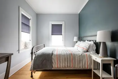 a bedroom with a bed and two windows at Hudson Valley Retreat in Downtown Hudson, NY - Sleeps 16-20 in Hudson