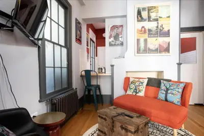 a living room with an orange couch and a table at Hudson Valley Retreat in Downtown Hudson, NY - Sleeps 16-20 in Hudson