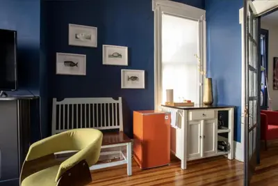 a living room with a yellow chair and a blue wall at Hudson Valley Retreat in Downtown Hudson, NY - Sleeps 16-20 in Hudson