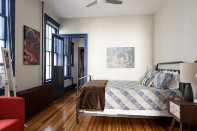 a bedroom with a bed and a red chair at Hudson Valley Retreat in Downtown Hudson, NY - Sleeps 16-20 in Hudson