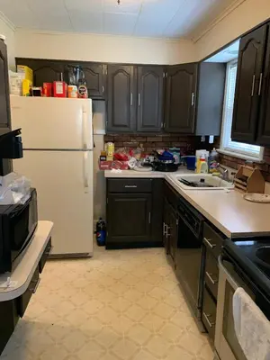 a kitchen with black cabinets and a white refrigerator at Luke's BnB in Albany
