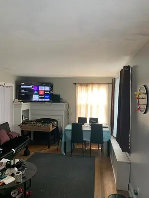 a living room with a table and a room with a piano at Luke's BnB in Albany