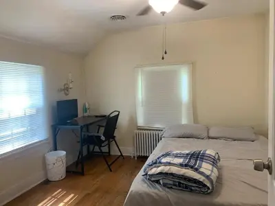 a bedroom with a bed and a desk with a chair at Luke's BnB in Albany