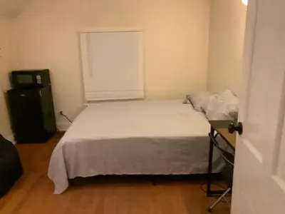 a small bedroom with a bed and a window at Luke's BnB in Albany