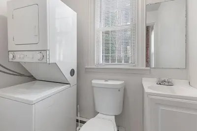 a white bathroom with a toilet and a sink at Frog Hollow Red Door Retreat in Hartford