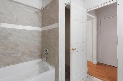 a bathroom with a tub and a white door at Frog Hollow Red Door Retreat in Hartford