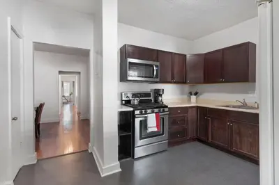 a kitchen with wooden cabinets and a stove top oven at Frog Hollow Red Door Retreat in Hartford