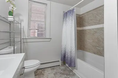 a white bathroom with a toilet and a shower at Frog Hollow Red Door Retreat in Hartford
