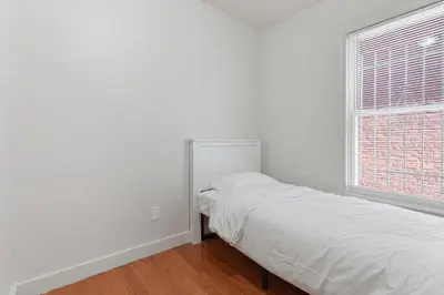 a white bedroom with a bed and a window at Frog Hollow Red Door Retreat in Hartford