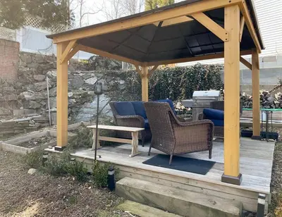 a wooden gazebo with two chairs and a table at Luxury Suite with water view - 2 mini bedrooms in Greenwich