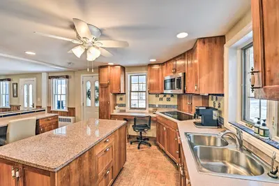 a kitchen with wooden cabinets and a ceiling fan at All Year-Round Retreat Near Windham Mountain in Conesville