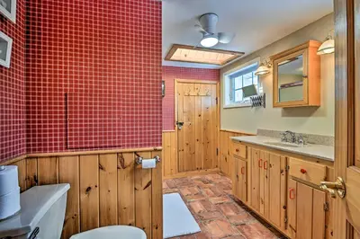 a bathroom with a toilet and a red tiled wall at All Year-Round Retreat Near Windham Mountain in Conesville
