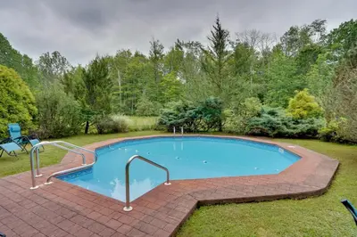 a swimming pool in a yard with a brick patio at All Year-Round Retreat Near Windham Mountain in Conesville