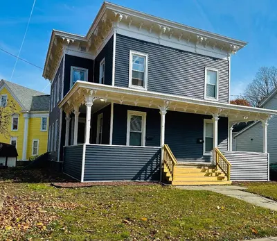 a blue house with a porch and a yellow house at Triple Play Apt 1 All Star Baseball Rentals in Oneonta