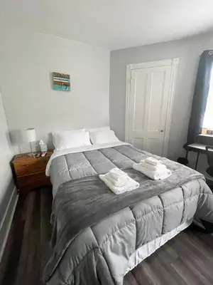 a bedroom with a large bed with two towels on it at Triple Play Apt 2 All Star Baseball Rentals in Oneonta