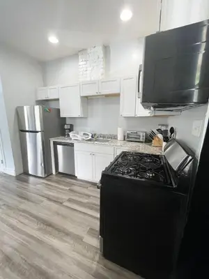a kitchen with white cabinets and a black stove at Triple Play Apt 2 All Star Baseball Rentals in Oneonta