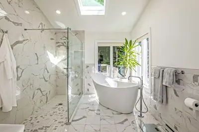 a bathroom with a tub and a glass shower at Lakefront Otis Home with Stunning Views and Boats! in Otis