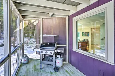 a grill on the porch of a purple house at Lakefront Otis Home with Stunning Views and Boats! in Otis